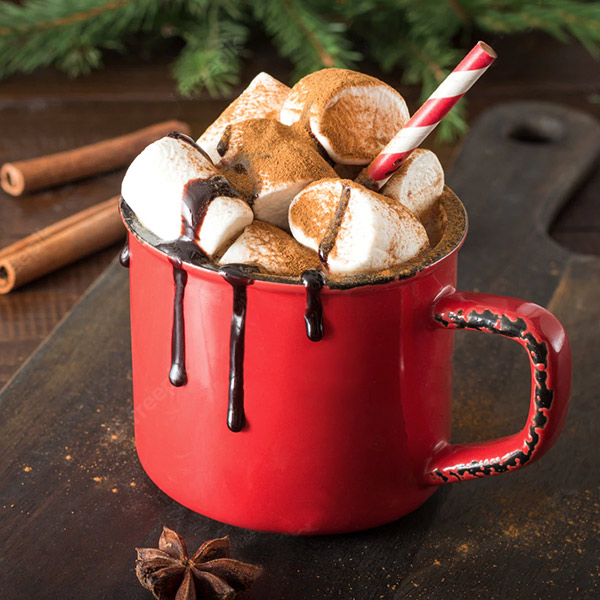 Chocolate Cherry Warmer in a red mug, with chocolate dripping down the side the top is stuffed with marshmallows and garnished with a candy cane